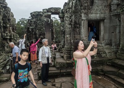 Des touristes asiatiques font des photos dans un temple à Angkor au Cambodge