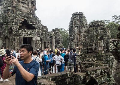 Des touristes asiatiques font des photos dans un temple à Angkor au Cambodge