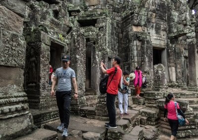 Des touristes asiatiques font des photos dans un temple à Angkor au Cambodge
