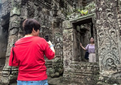 Touristes asiatiques se prenant en photo dans un temple à Angkor au Cambodge