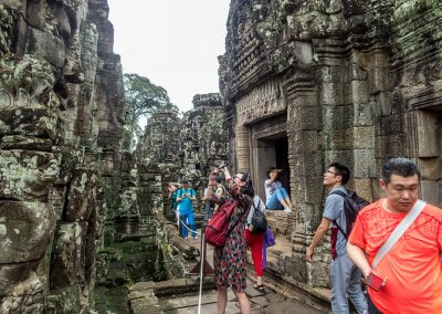 Des touristes asiatiques font des photos dans un temple à Angkor au Cambodge