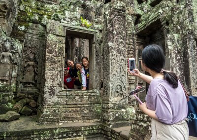 Touristes asiatiques se prenant en photo dans un temple à Angkor au Cambodge